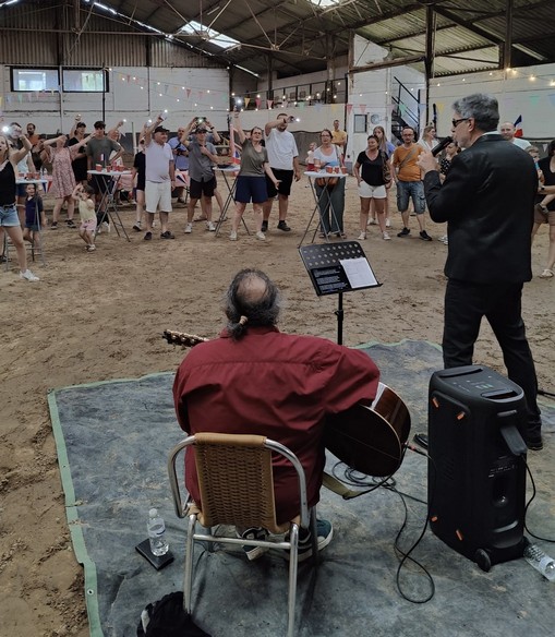 Chris et son guitariste devant un public debout