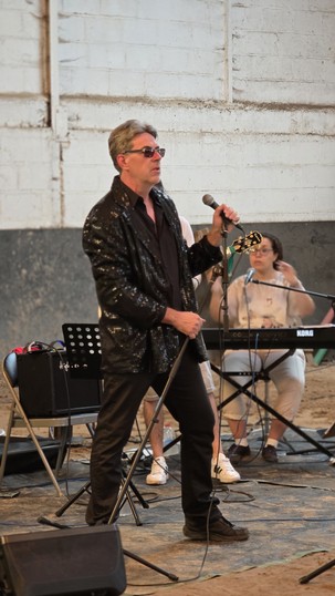 Chris Légendes sur scène, veste en cuir et lunettes noires